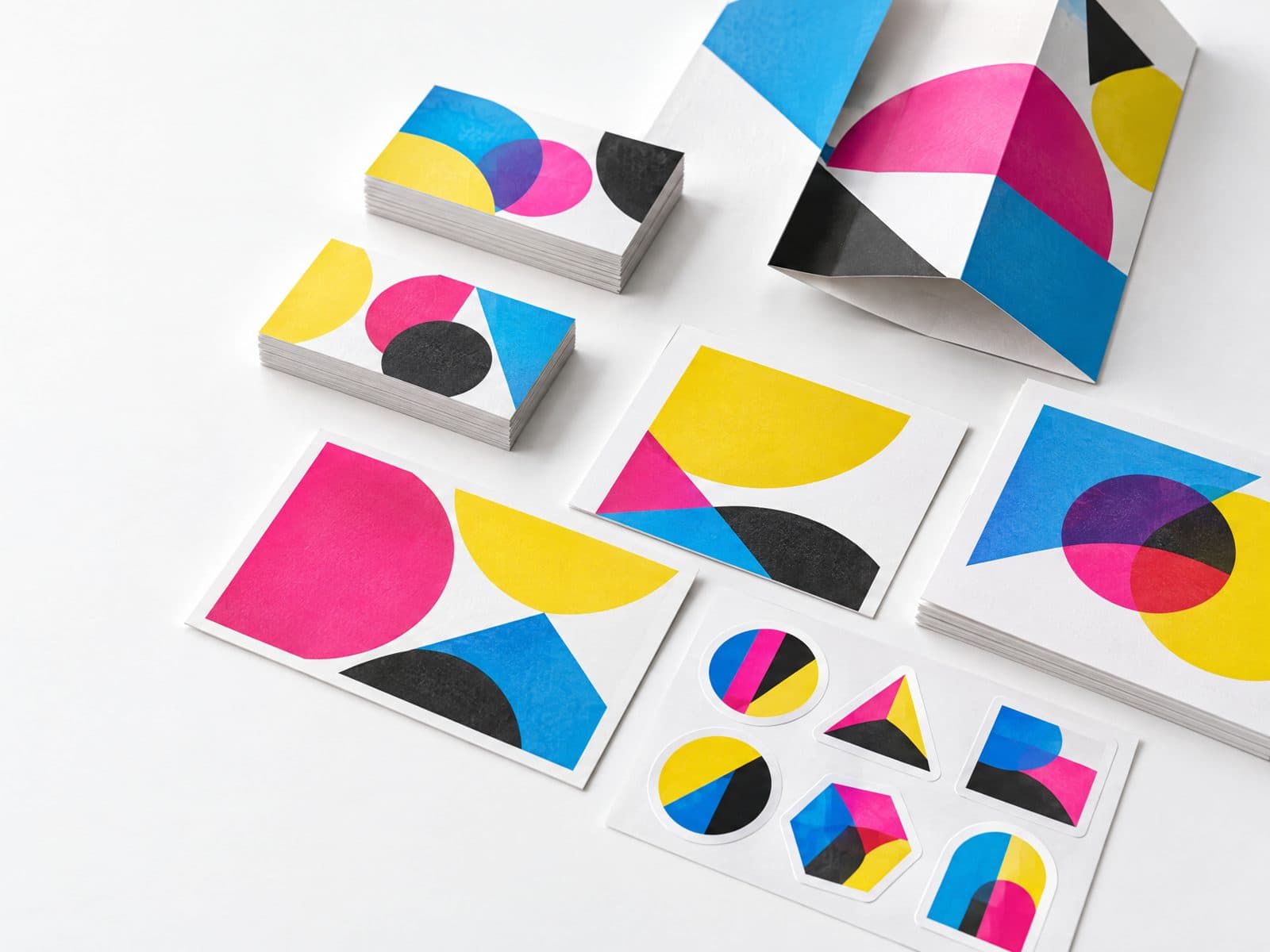 Business cards, postcards, brochures and stickers laid out on a white table